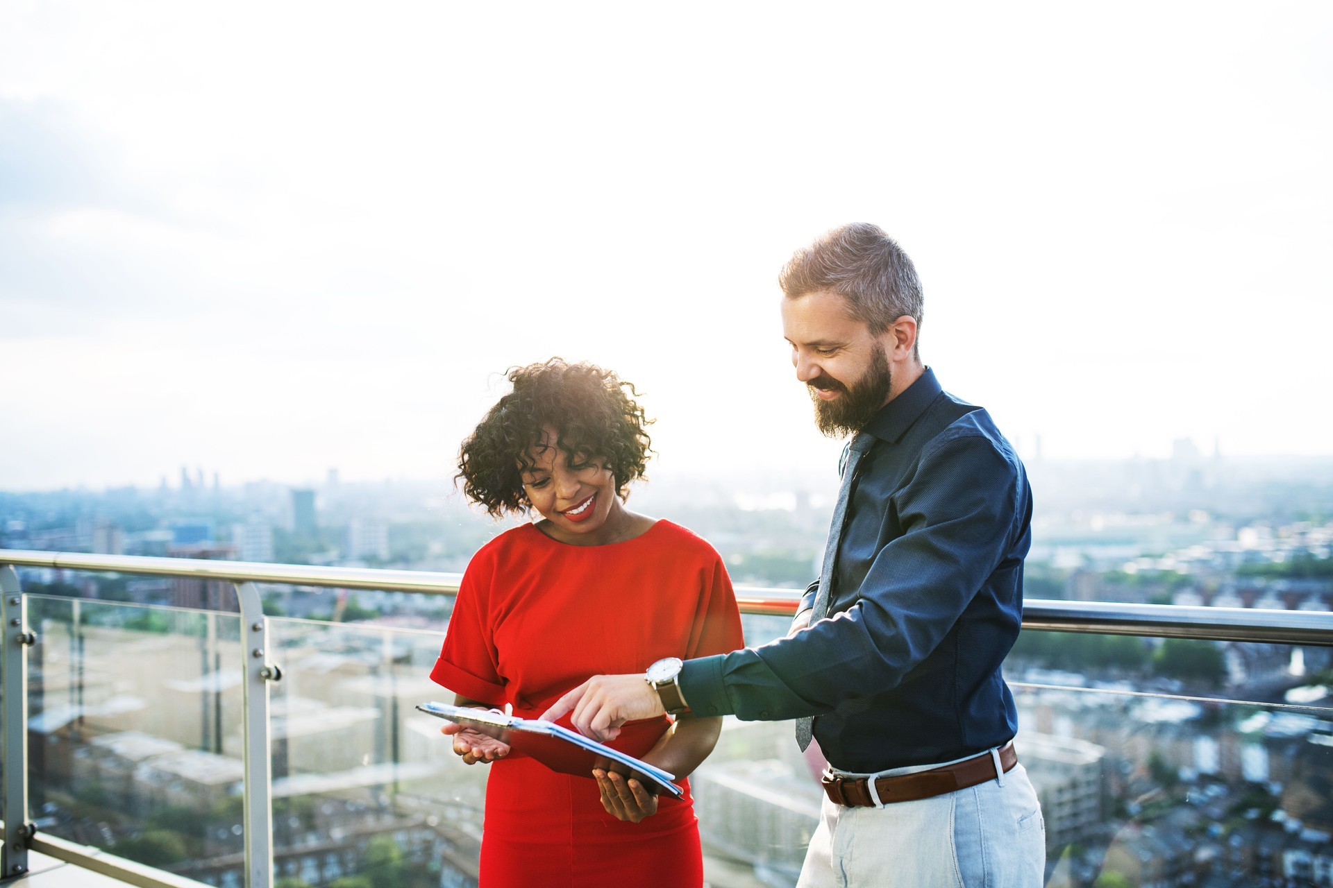 A portrait of two businesspeople standing against London view panorama.